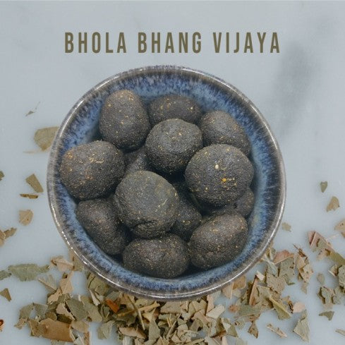 Bhola Munakka Bhang Goli Vijaya Vati in a ceramic bowl with dried cannabis leaves – handcrafted traditional Ayurvedic bhang goli by AquaHerbals India